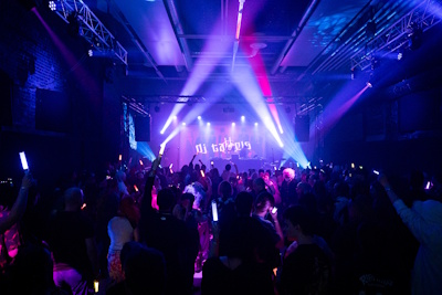 Sali täynnä ihmisiä, joilla on eri värisiä valotikkuja käsissään. Ihmiset ovat pukeutuneet erilaisiin bileasuihin. Ihmiset tanssivat lavalla olevan DJ musiikin tahtiin. Lavan sivuilla ja katossa on värivaloja, joiden valot valaiset yleisöä. DJ takana on videotykin heijastama DJ:n logo.